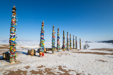 Wooden ritual pillars with colorful ribbons on cape Burkhan