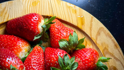 Juicy strawberries glisten on rustic wooden platter, invoking summer solstice picnics and whimsical strawberry moon feasts