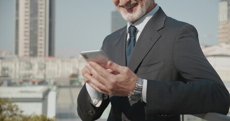 Smiling entrepreneur reading document on smartphone, mobile business, success