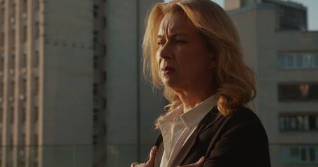 Lonely businesswoman standing alone on city street, sad memories, work failure