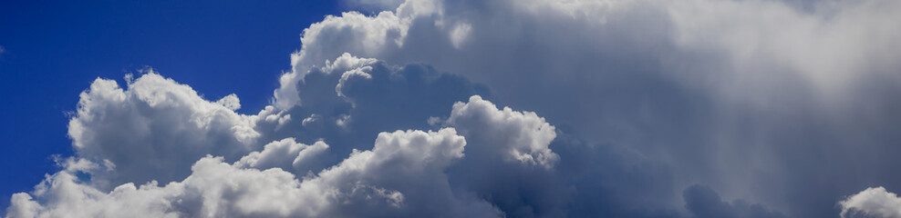 Majestic clouds gather in a vibrant blue sky, casting shadows and inviting the wonder of nature's beauty during the day