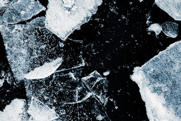 Broken textured ice. Crushed natural textured ice on a black background, close-up.