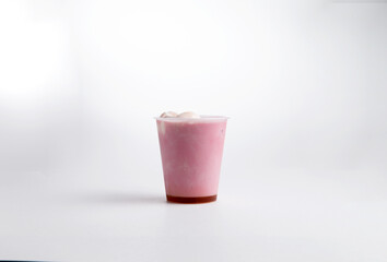 Milkshake with red syrup and ice cream in a glass. on a white background.