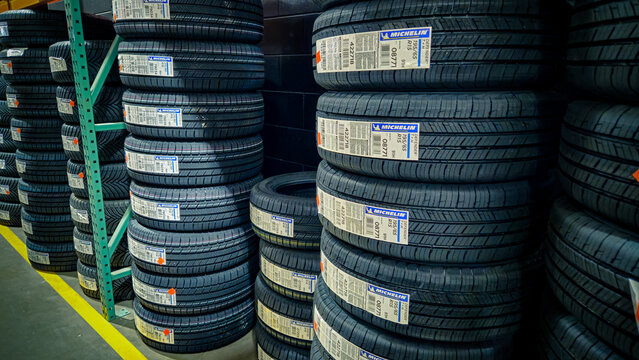 A close-up of tires stacked high for sale in a Costco wholesale store with a visible Michelin brand logo.