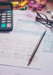 Planning, Budget, and Tax Concept. Individual Income 1040 Tax Form For Have Income According to United States Law. Tax form, calculator, and pen on desk. Season to pay, and deadline for tax payment.