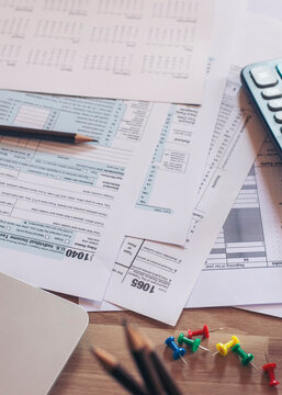 Planning, Budget, and Tax Concept. Individual Income 1040 Tax Form For Have Income According to United States Law. Tax form, calculator, and pen on desk. Season to pay, and deadline for tax payment.