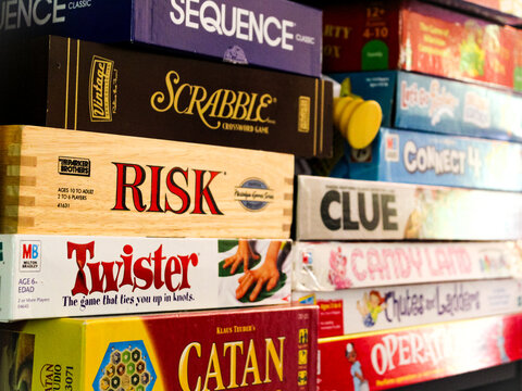 A collection of classic board games on a shelf. Editorial Use Only.