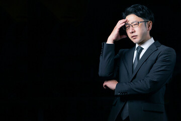 暗闇の中で悩んでいるビジネスマン