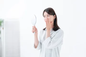 Fotobehang 手鏡を見て悩む女性 © naka