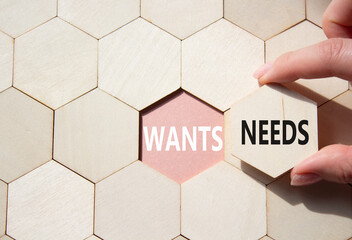 Wants and Needs symbol. Concept word Wants and Needs on wooden comb puzzle. Businessman hand....