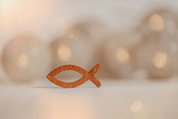 Kommunion, Konfirmation, Taufe - kleiner Fisch aus Holz auf neutralen Hintergrund mit Lichtern