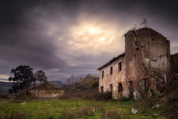 Ruins of an abandoned mining village in Burzako, Basque Country, Spain. Dramatic sky over decaying...