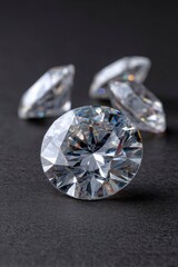 Three diamonds rest on a gray textured surface with one dominant in the foreground