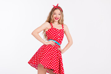 Charming young woman in a polka dot red dress showcasing a vintage retro dance style with vibrant...