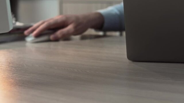 manager swipes a laptop mouse across the desk