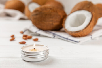 Natural coconut wax candles on a wooden table. Homemade eco-friendly coconut wax candles with aromatic oil. Candles for massage. Spa. Relax. Aromatherapy. Copy space. Vegan product.