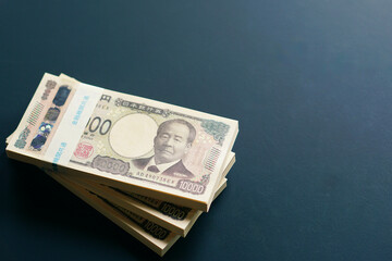 黒いテーブルに置かれた一万円札の札束