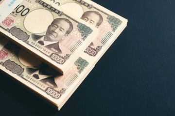 黒いテーブルに置かれた一万円札の札束