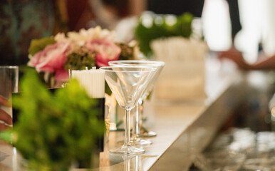 side view of a bar counter with two empty martini glasses at an event
