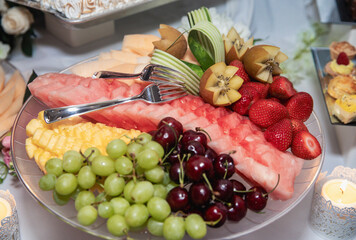 close up view of a plate filled with fruit on a desert table at a buffet with raisins and melons
