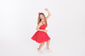 Plakat Young woman in retro red polka dot dress dancing joyfully against white background