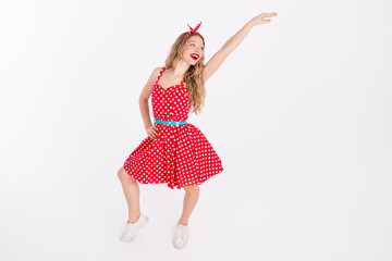 Young woman dancing in a retro polka dot dress showcasing joyful motion and stylish confidence,...