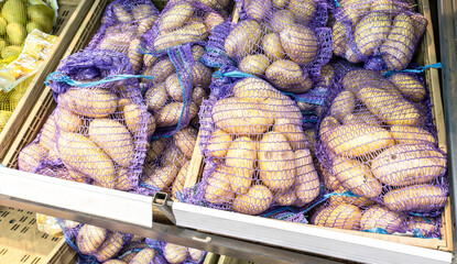 Fresh potatoes packed in bags selling at the grocery store