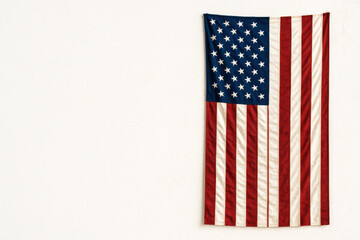American flag displayed on a white wall indoors  