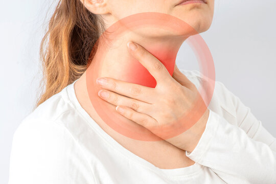 Woman holding her throat with her hand. Neck pain, cold, thyroiditis, thyroid gland.