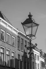Street lamp illuminating traditional dutch houses under blue sky