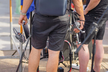 Men holding drone and tablet at an outdoor event. Drone operators preparing for an aerial shoot,...