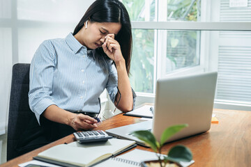 Business woman is stress and holding eyeglasses feeling of pain in the eyes, headache and tired from hard work