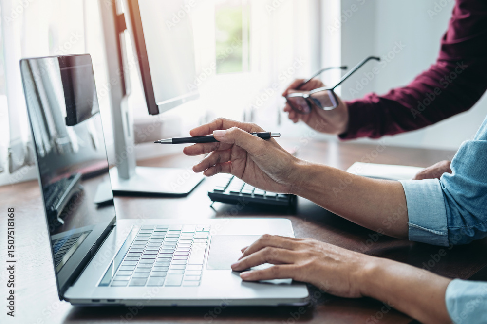 Poster asian woman programmer holding pen to pointing on screen laptop during brainstorming with partner