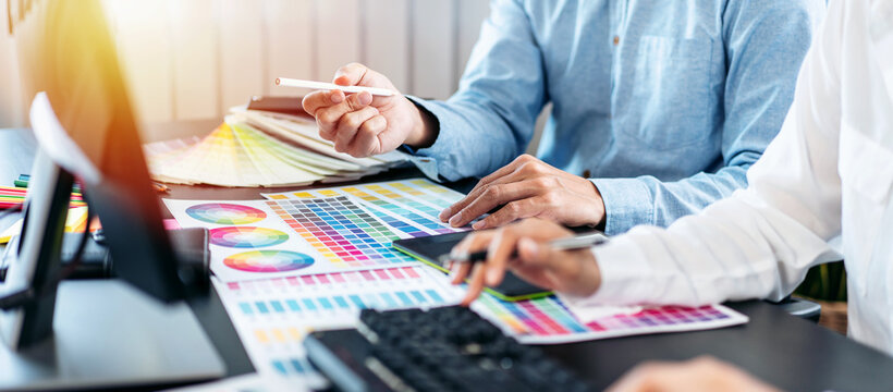 Team of creative graphic designer working on color swatch samples chart for selection coloring in inspiration to create new collection at workplace