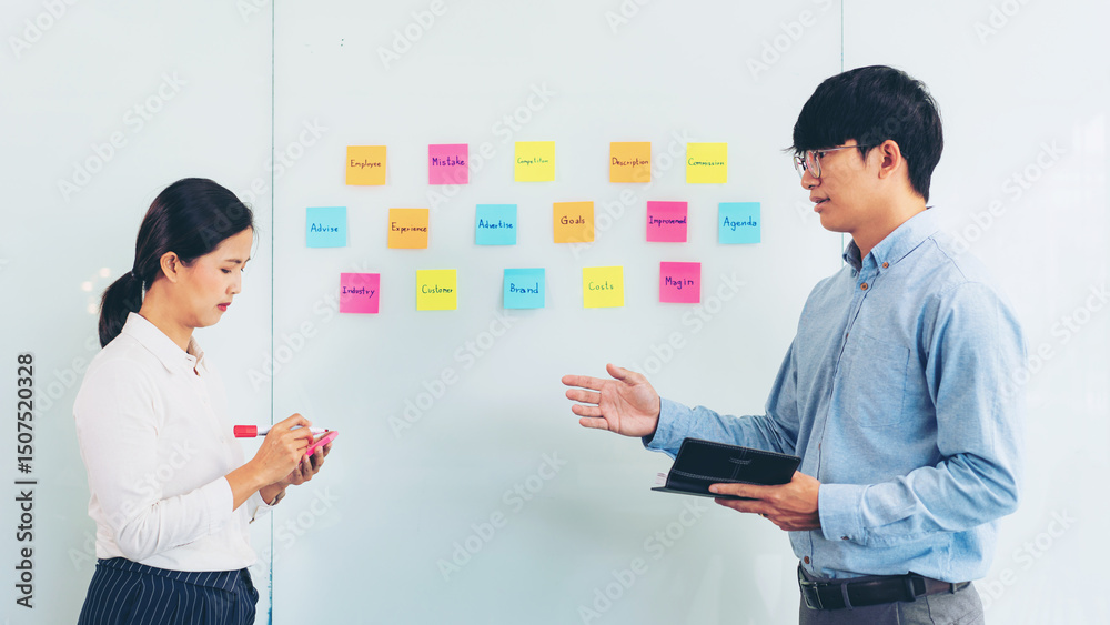 Poster two business executive team holding and taking notes keyword on board wall to brainstorm about a new