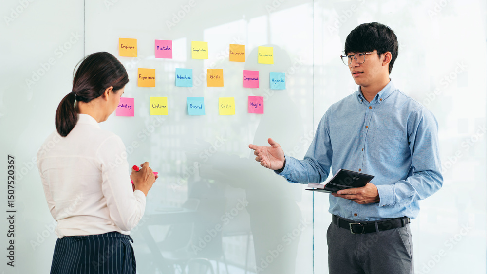 Poster two business executive team holding and taking notes keyword on board wall to brainstorm about a new