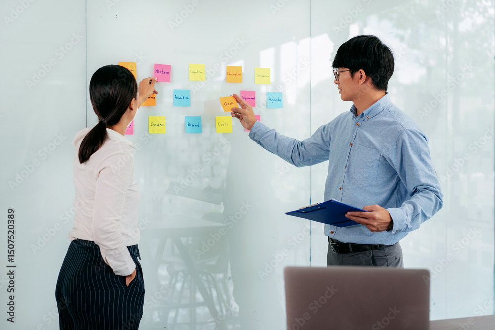 Poster two business executive team holding and taking notes keyword on board wall to brainstorm about a new