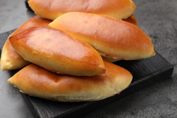 Tasty baked patties on grey textured table, closeup