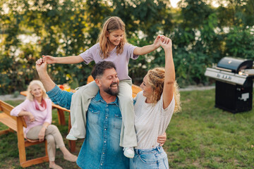 Happy family having fun in the garden during a barbecue party