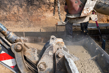 Construction workers pouring concrete on job site straight from delivery truck