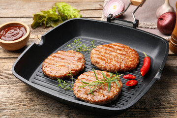 Delicious hamburger patties and spices on wooden table, closeup