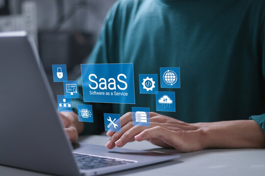 SaaS, Software as a service concept. Internet and networking technology. Businessman using laptop with SaaS icons for software services on cloud system.