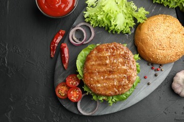 Delicious hamburger with patty served on black table, flat lay. Space for text
