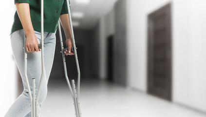Woman with axillary crutches in hospital, closeup. Banner design