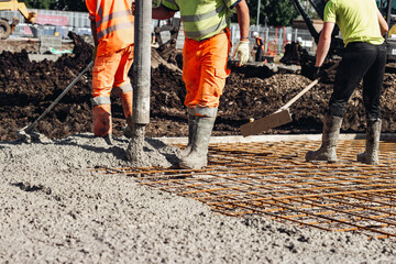 Concreter using concrete pump to pour wet concrete at building site