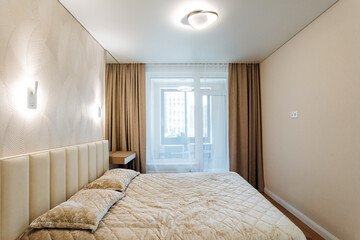 The bedroom features a comfortable bed, a window adorned with elegant curtains, making it a cozy and inviting space to relax in. It truly embodies a harmonious interior design