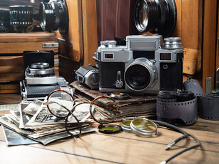 Old cameras are arranged in a composition on a wooden background, on a table.