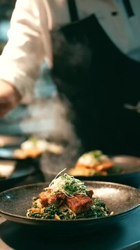 Chef plating a vegetable dish in a busy restaurant kitchen