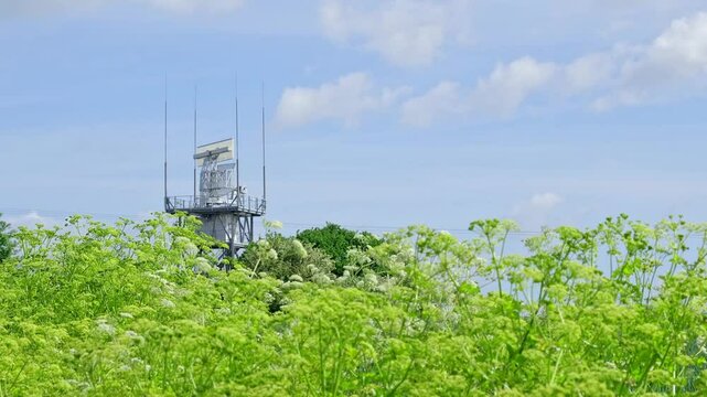 Rotating radar detector carrying out important surveillance on top of a tower in the countryside