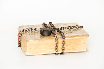 Old book wrapped with metal chain with lock on white